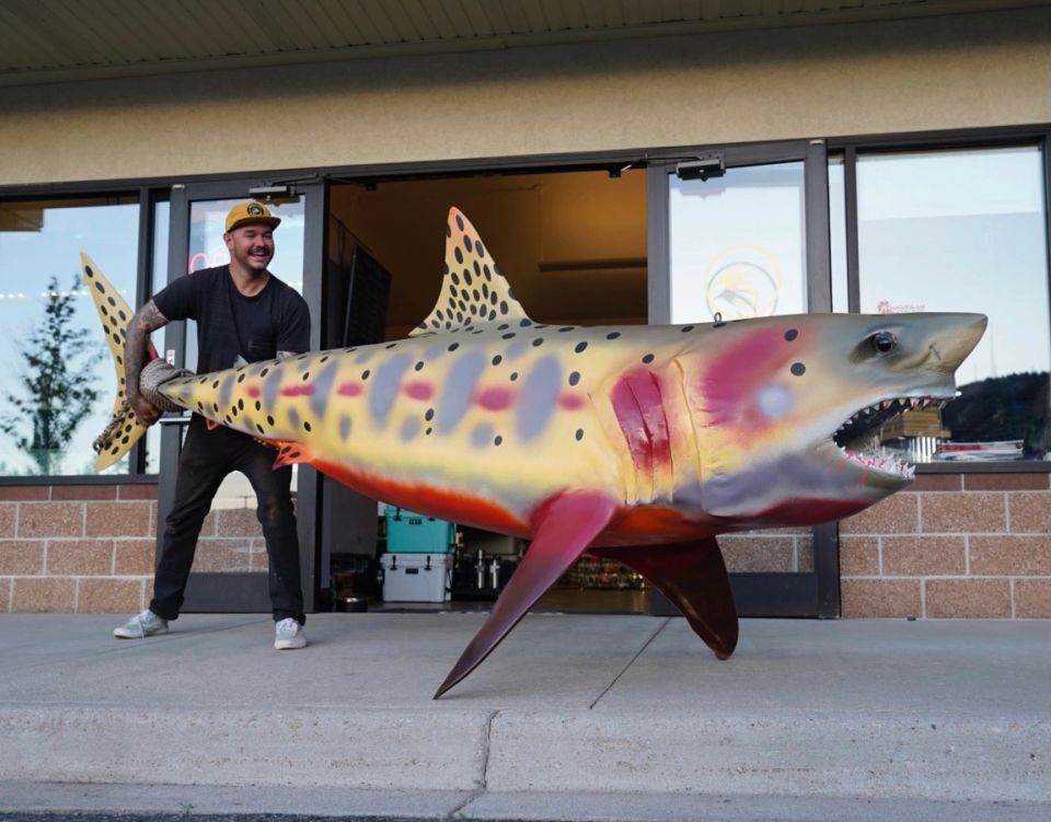Drew with a big fish statue looking excited